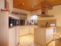 Küche in beige mit Holz-Arbeitsplatte beleuchtet