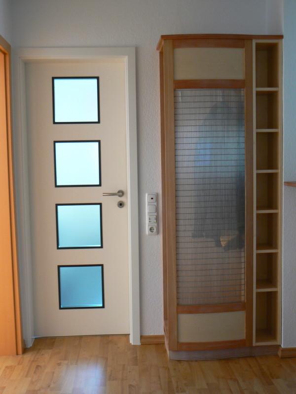 Garderobe und Innentür in weiß mit vier schwarz umrandeten Lichtausschnitten
