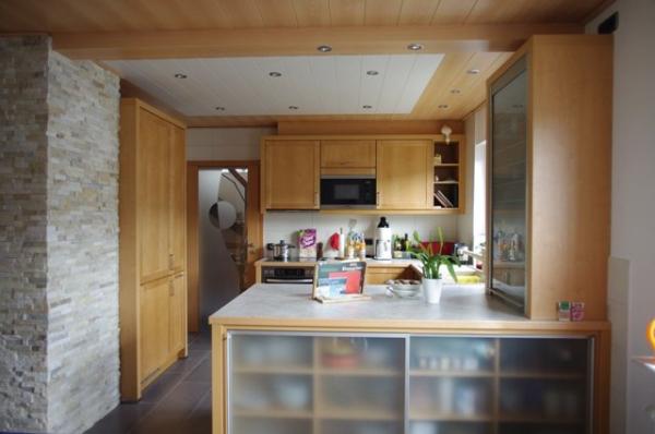 Holzküche mit heller Arbeitsplatte und Schrank mit Milchglas-Türen 