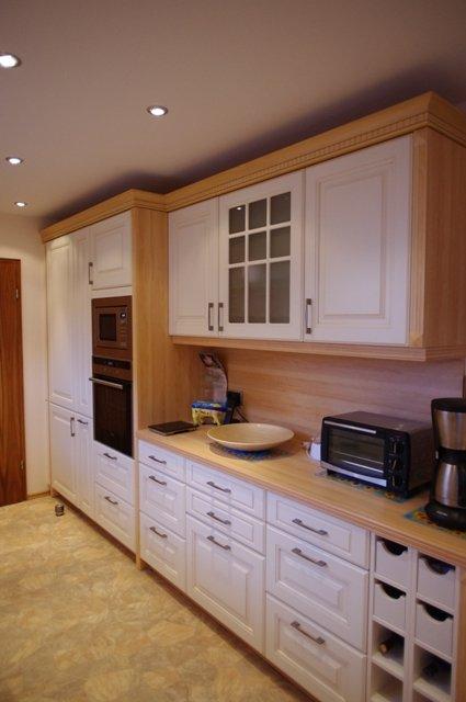 Küche in weiß mit Holz-Arbeitsplatte und Weinfächern 