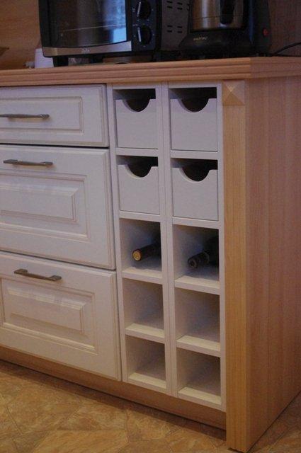 Küche in weiß mit Holz-Arbeitsplatte und Weinfächern 
