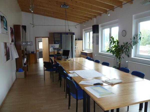 Besprechungsraum mit Holztischen und blauen Stühlen 