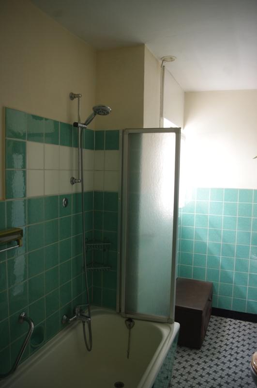 Badezimmereinrichtung vor der Renovierung mit grünen Fliesen 