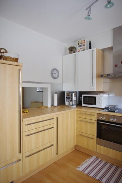 Holzküche mit Durchgabe mit weißen Hängeschränken