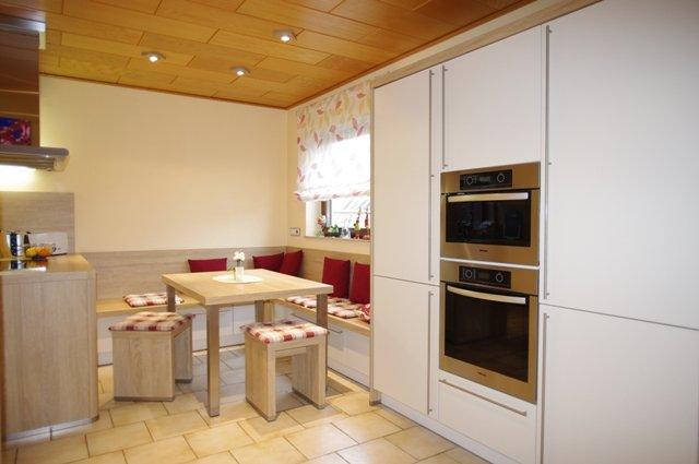 Küche in weiß und Holz-Sitzgruppe und Eckbank
